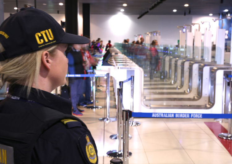 Border control employee looking at smart borders passenger lines